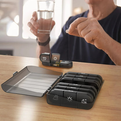 senior man taking his daily vitamins and medication using the organized weekly pill box system