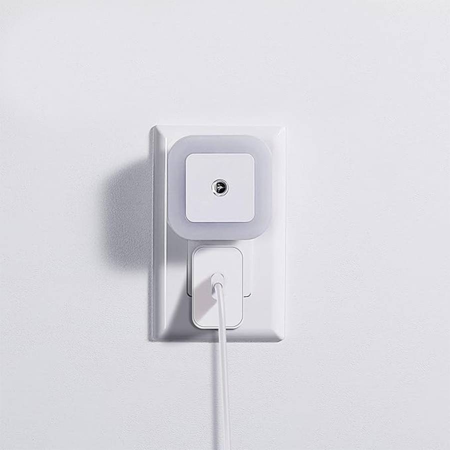 Compact motion sensor light plugged into a wall outlet, showing its space-saving design.