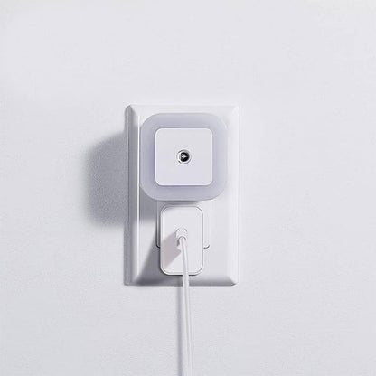 Compact motion sensor light plugged into a wall outlet, showing its space-saving design.