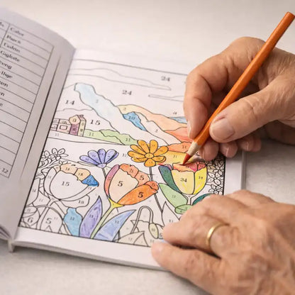 Close-up of a senior's hand coloring a floral design in the color by number book.