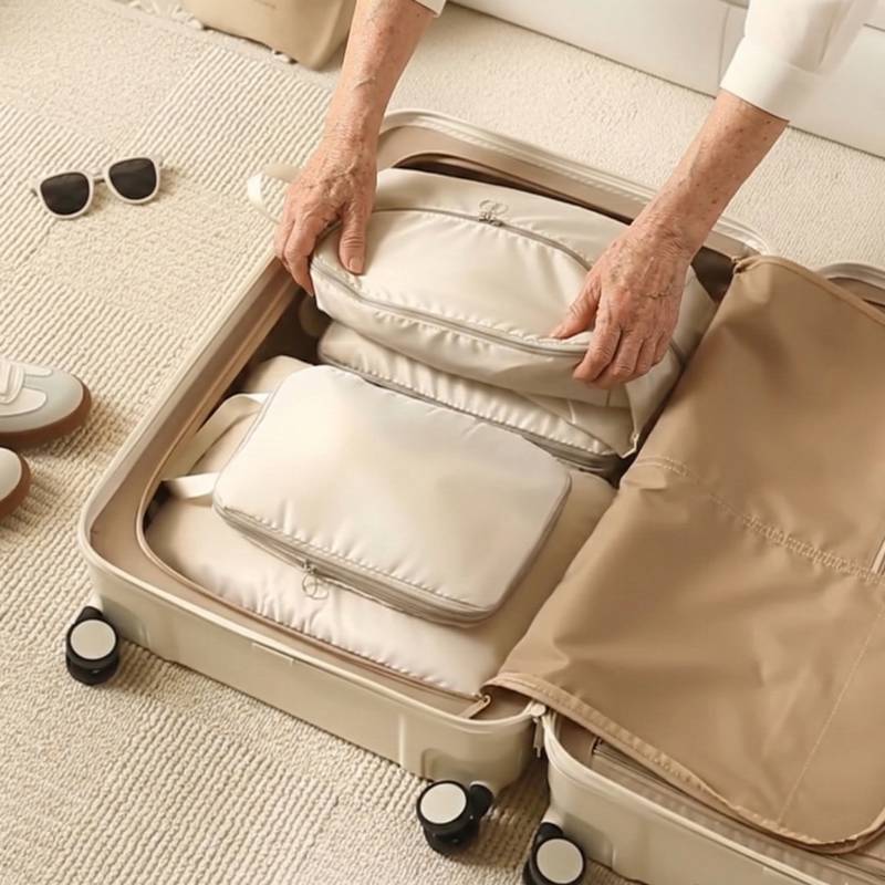 open suitcase showing how beige compression cubes maximize space and organize travel luggage
