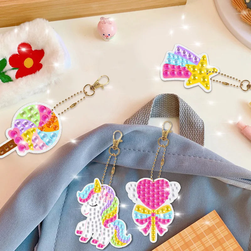 Finished unicorn diamond painting keychains hanging on a blue backpack.