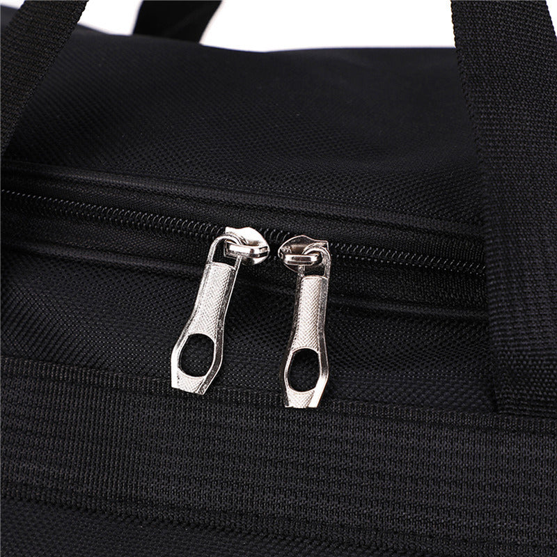 close-up detail of high-quality dual metal zippers on a black water-resistant travel duffel bag