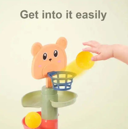 close-up of a child's hand dropping a yellow ball into the Montessori toy's basketball hoop