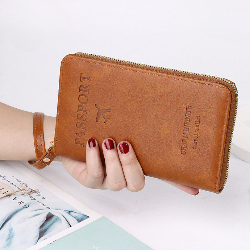 close-up of a person holding the slim brown travel wallet with a secure wrist strap