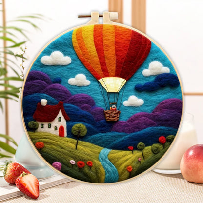 Close-up of the finished Countryside Balloon needle felting landscape in an embroidery hoop.