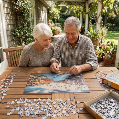 An elderly couple enjoyably assembling the Scenic World Traveler jigsaw puzzle on an outdoor patio table.