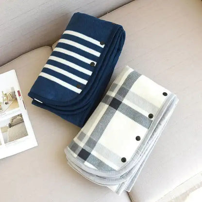 folded navy blue and light gray plaid wearable blankets showing compact storage for easy travel