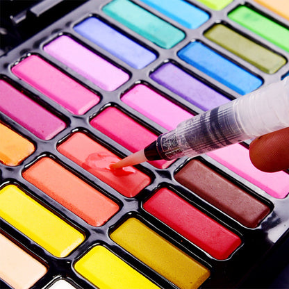 close-up of a water brush picking up vibrant pigment from a 36-color non-toxic watercolor palette