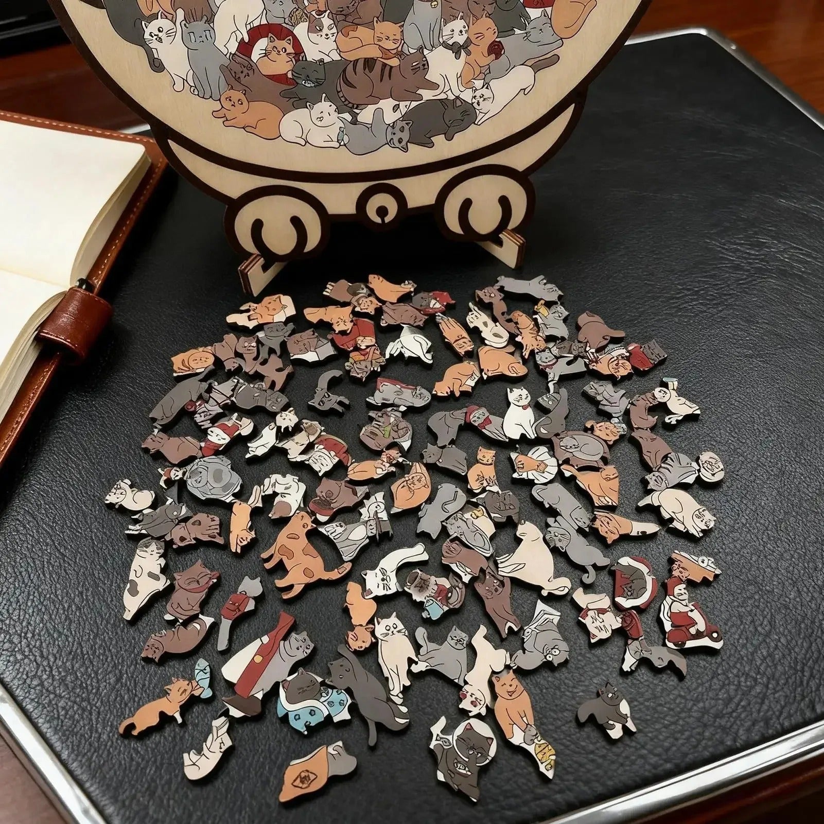 High-detail shot of the various uniquely shaped wooden cat pieces spread on a dark surface.